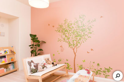ピンクの壁に描かれた木のグラフィック。楽しげで子ども部屋にもぴったりです。